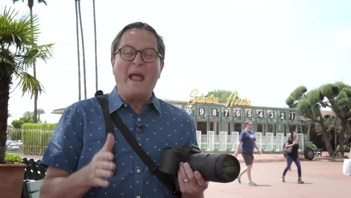 Photographer setting shutter speed on camera body