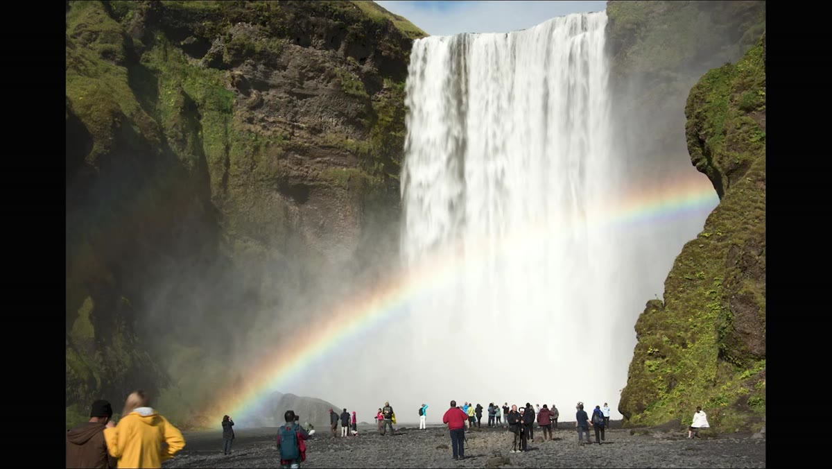 Tripod set up at Icelandic waterfall with crowds in foreground