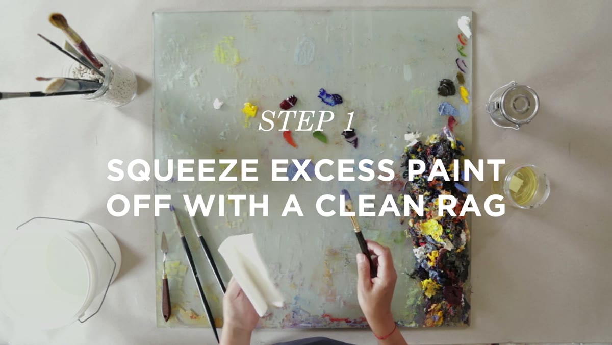 Artist pressing loaded brush into clean cloth rag